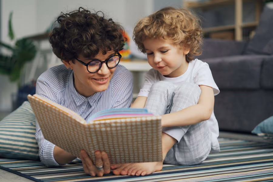 Mãe e criança pequena olhando um livro ilustrado